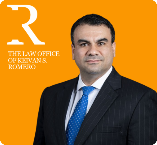 Portrait of a man in a dark pinstripe suit, white shirt, and blue tie, standing against an orange background with the logo and text ‘The Law Office of Keivan S. Romero’ on the left.