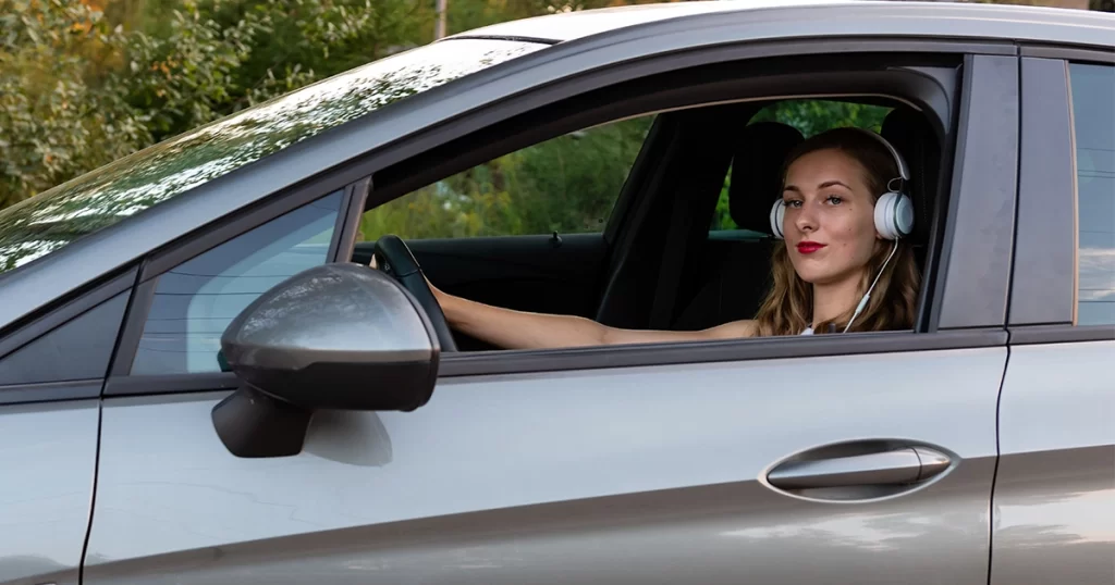 Driver wearing headphones while driving, potentially violating traffic laws